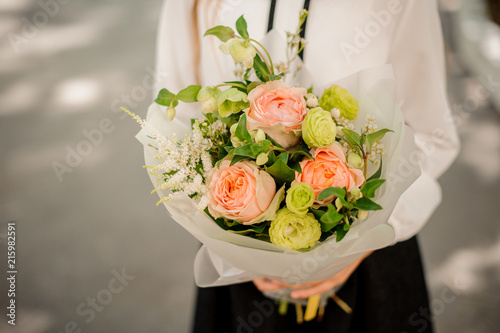 School girl holding a bright festive bouquet of roses