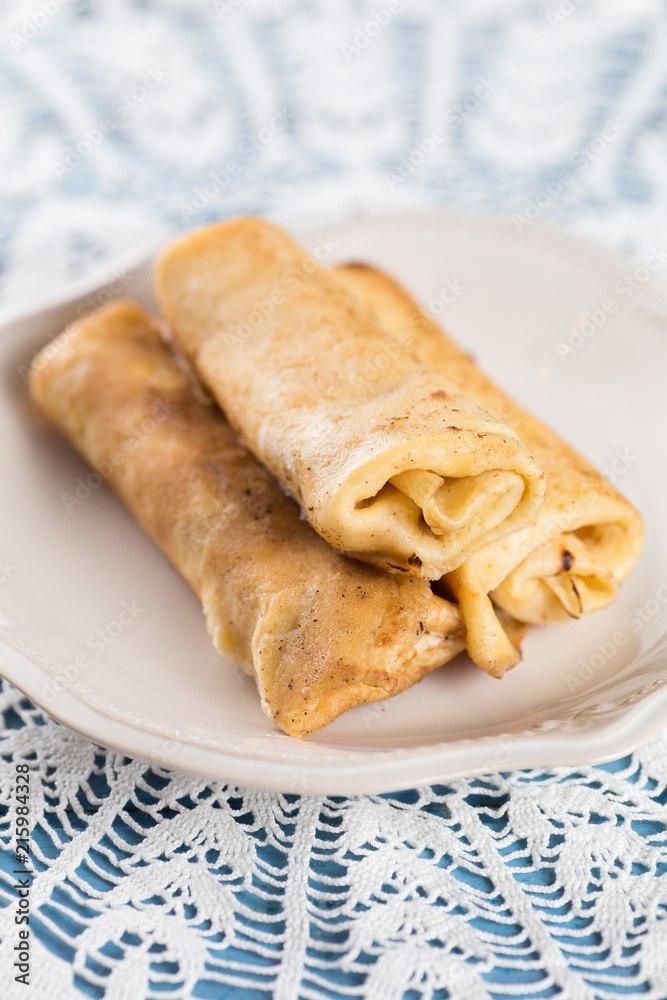 Three homemade rolled pancakes on plate