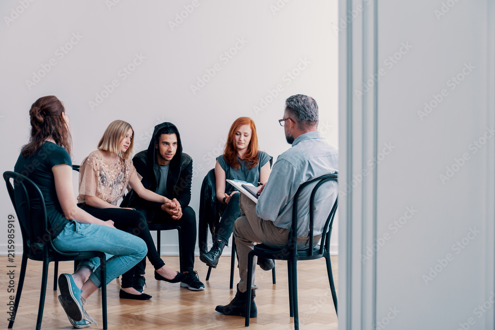 Fototapeta premium Grupa wsparcia siedząca w kręgu i rozmawiająca z psychiatrą