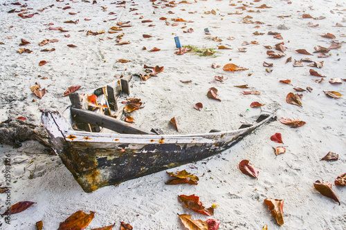 rotten fisher boat at the beach vovered partly by sand photo