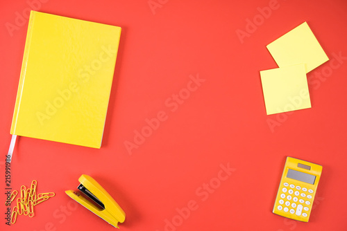 top view of various yellow office appliances on red