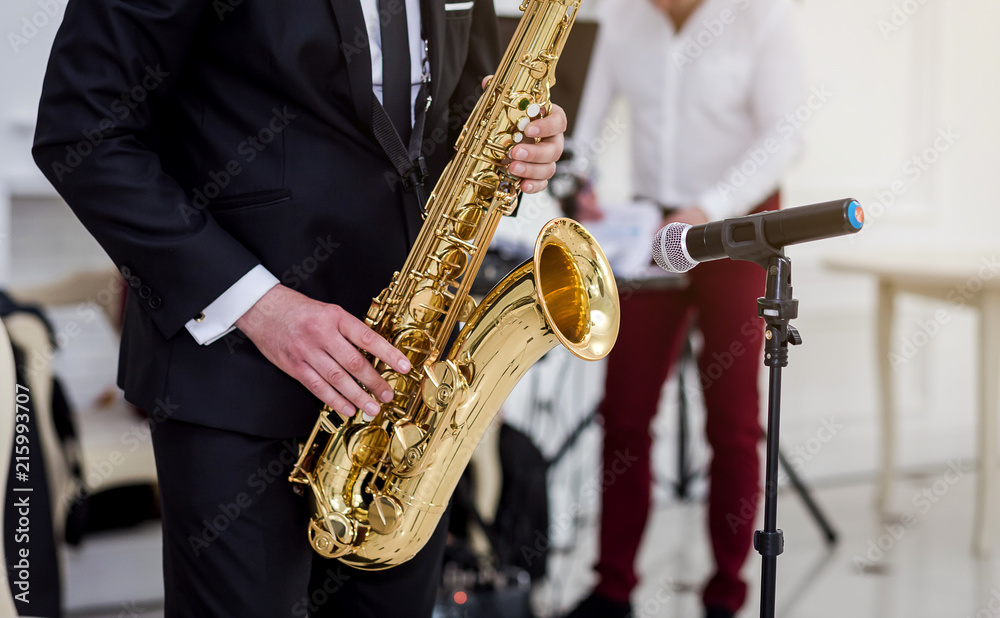Naklejka premium Gold saxophone with specks on it in male hands