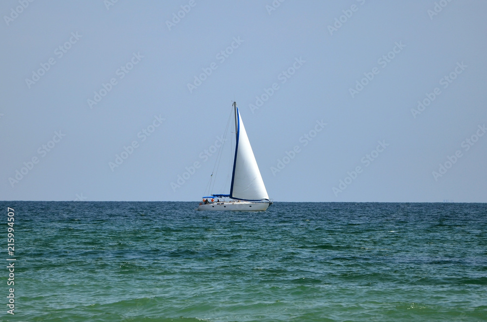 The sailboat sails on the sea.