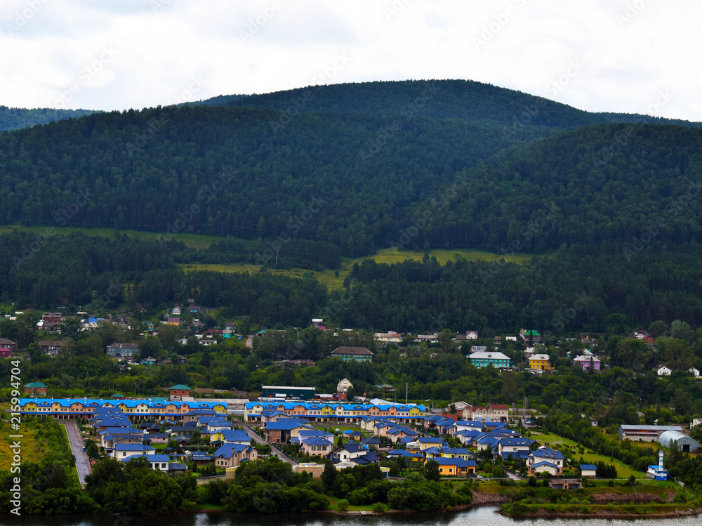 A small village located at the foot of the mountain. Beautiful mountain view. Siberian nature. Attractions Of Krasnoyarsk Region.