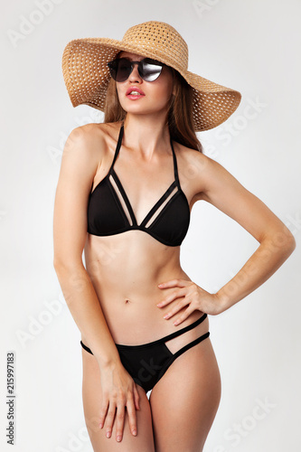 Beautiful woman in black bikini and big straw hat