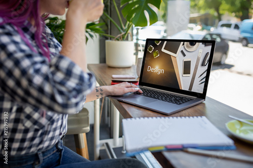 Cropped shot view of young woman working on laptop computer while sitting in modern cafe bar interior. Design. Web design photo