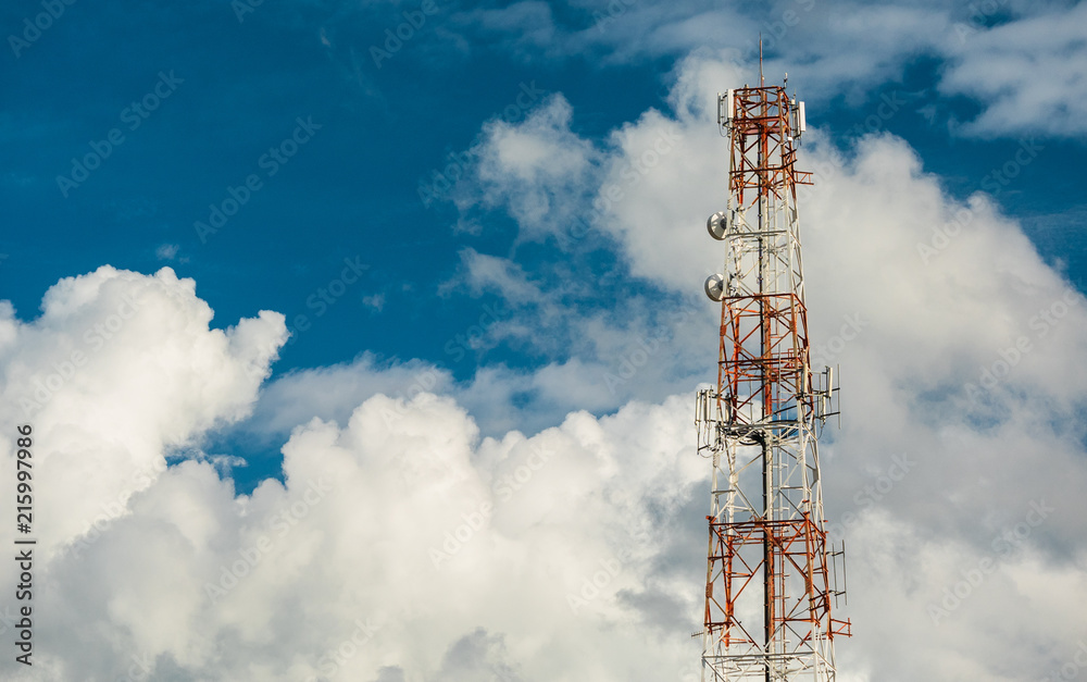 Telecommunication antenna on the top of the telecommunications service provider's building with clouds and  blue sky background in technology concept.