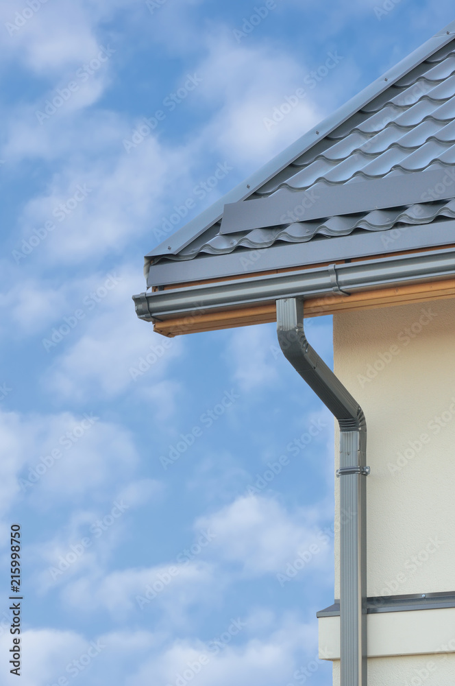 Grey Steel Tile Roof Texture Background, Gray Tiled Roofing, Beige Yellow Wall, Rain Gutter, Vertical Closeup, New House Rooftop Tiles Detail, Bright Blue Sky Clouds, Real Estate Property Concept Grey Steel Tile Roof Texture Background, Gray Tiled Roofing, Beige Yellow Wall, Rain Gutter, Vertical Closeup, New House Rooftop Tiles Detail, Bright Blue Sky Clouds, Real Estate Property Concept