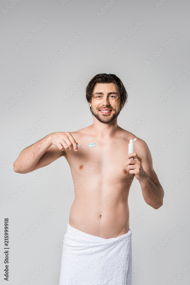 portrait of smiling man with toothpaste and toothbrush isolated on grey portrait of smiling man with toothpaste and toothbrush isolated on grey