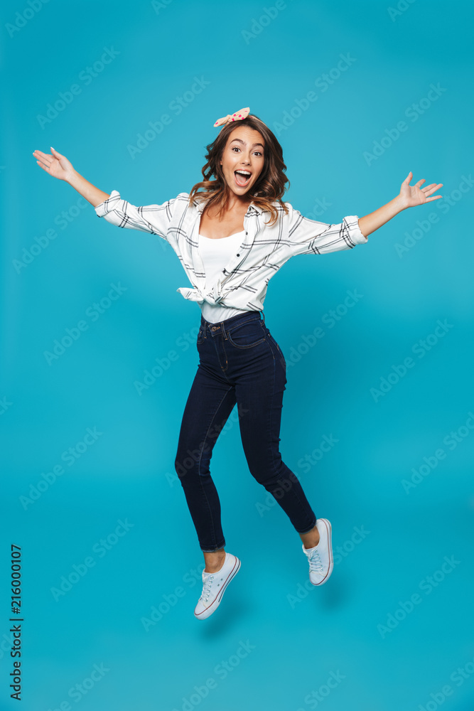 Obraz premium Full length portrait of a happy young housewife jumping