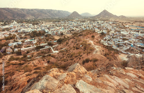 Landcape around indian city. Mountains and many buildings of Pushkar at evening, Rajasthan state, India.