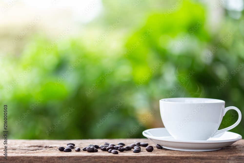 Coffee cup on wooden table or counter with green nature light blur background and space for text, design, photo montage or advertising Coffee cup on wooden table or counter with green nature light blur background and space for text, design, photo montage or advertising