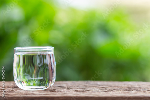 Close up clear eater in drinking glass on wooden table