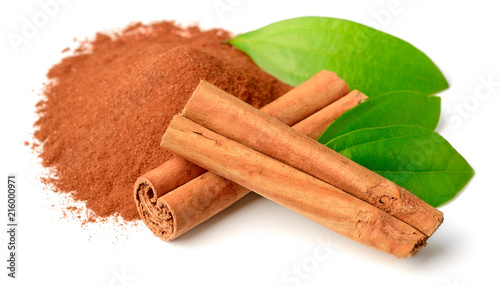 cinnamon powder and sticks with fresh leaves isolated on white