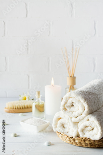 SPA aromatherapy background.  Still life with white towel, bath oil, massage brush and candle.