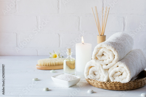 SPA aromatherapy background.  Still life with white towel, bath oil, massage brush and candle.