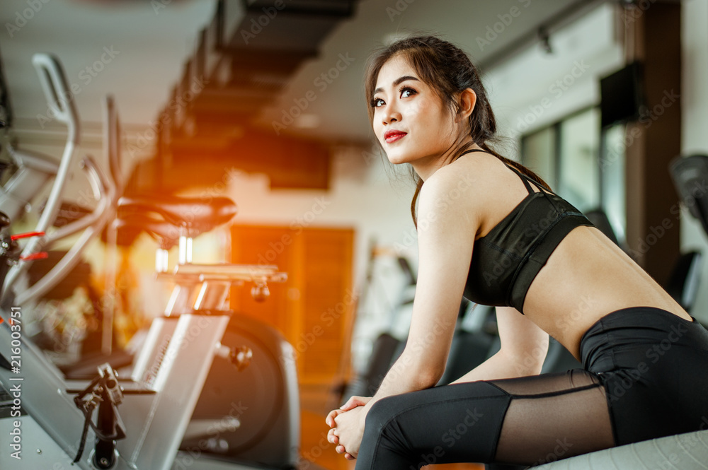 Fototapeta premium young fitness woman tired in gym drink protein shake.exercising concept.fitness and healthy lifestyle