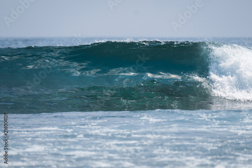 Perfect glassy ocean wave breaking on shore