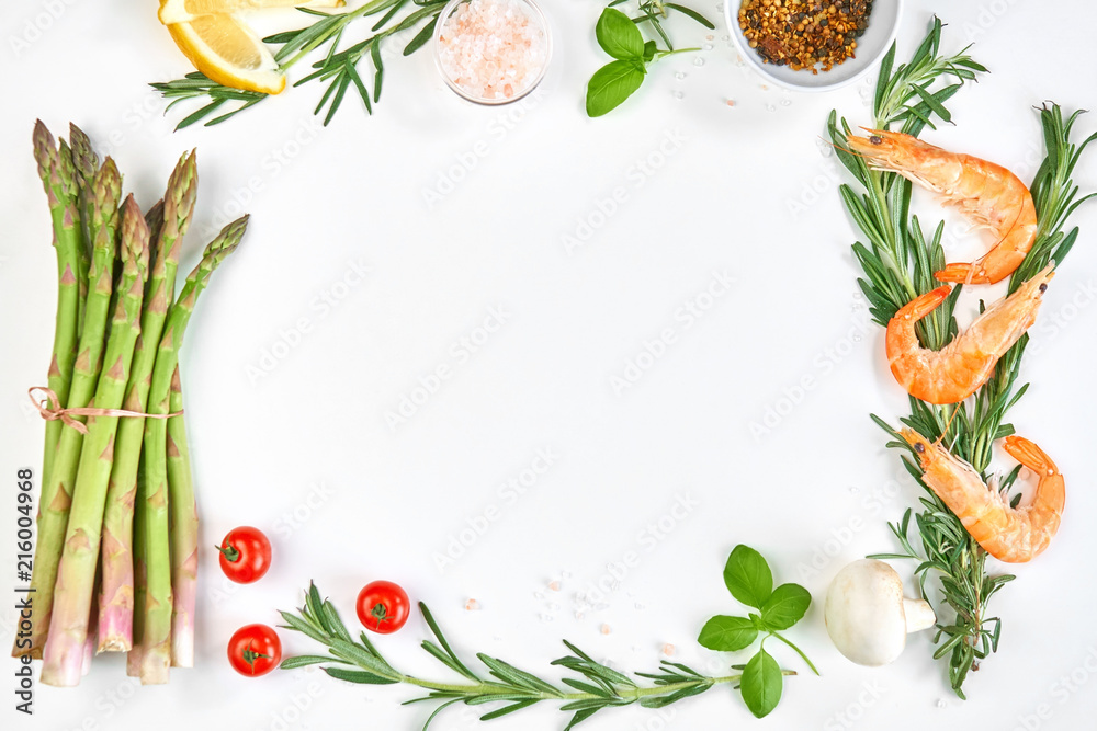 Frame-postcard from ingredients for cooking salmon fillets on a white background. Prepared ingredients for cooking sea fish, rosemary, basil, shrimp, cherry tomatoes, asparagus, lemon, spices,