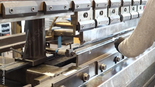 Man working a sheet metal on CNC hydraulic press brake. 4K UHD