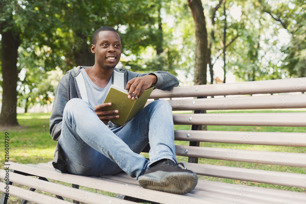 African-american student reading a book outdoors African-american student reading a book outdoors