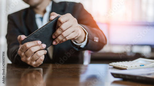 Businessman plying Video Games on his Smartphone During breaks.