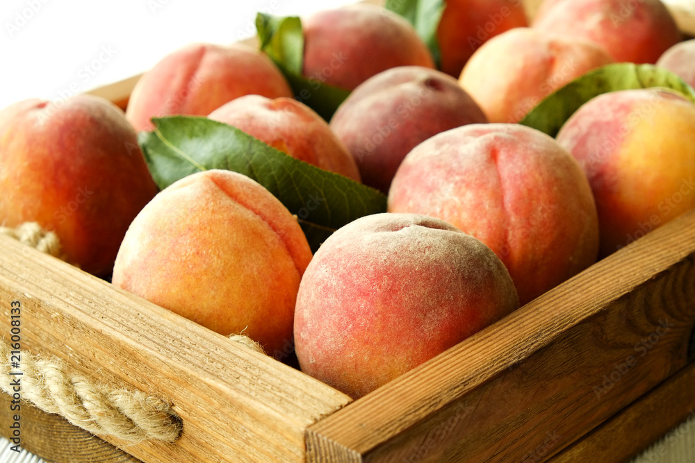 Bunch of ripe freshly picked organic peaches in pile on wooden tray of farmers market. Peach harvest heap. Healthy vegan raw snack. Clean eating concept. Cropped shot, background, top view, flat lay. Bunch of ripe freshly picked organic peaches in pile on wooden tray of farmers market. Peach harvest heap. Healthy vegan raw snack. Clean eating concept. Cropped shot, background, top view, flat lay.