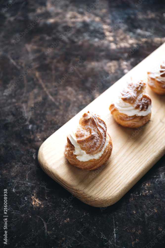 Choux pastry or choux cream or eclair dish on rustic background