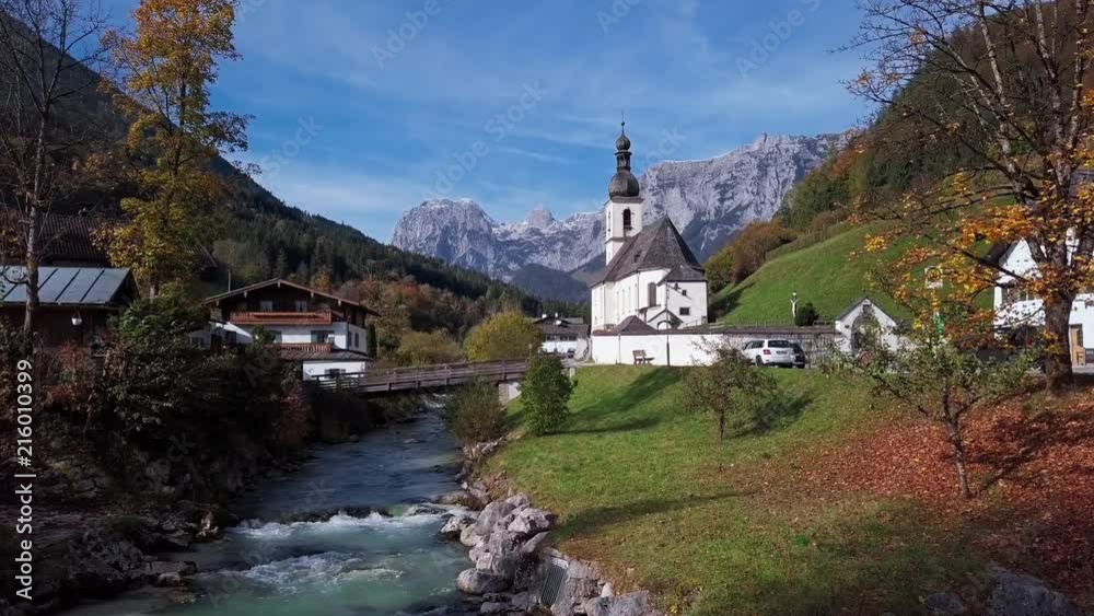 Flight over footbridge near famous Parish church St. Sebastian, in Ramsau, Berchtesgaden, Bavarian Alps Germany.