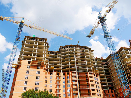 Construction site background. Two cranes near building. Construction site with crane and building.