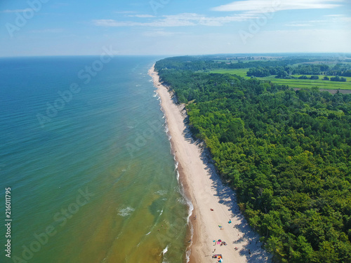Aerial view on baltic sea water with clean sand beach and forest
