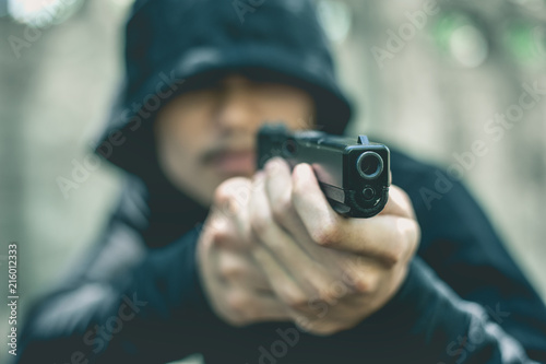 Robber with a gun robbing intimidate.Crime and robbery concept.