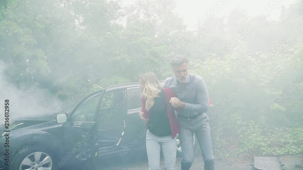 A mature man and a young woman running from the car after an accident.