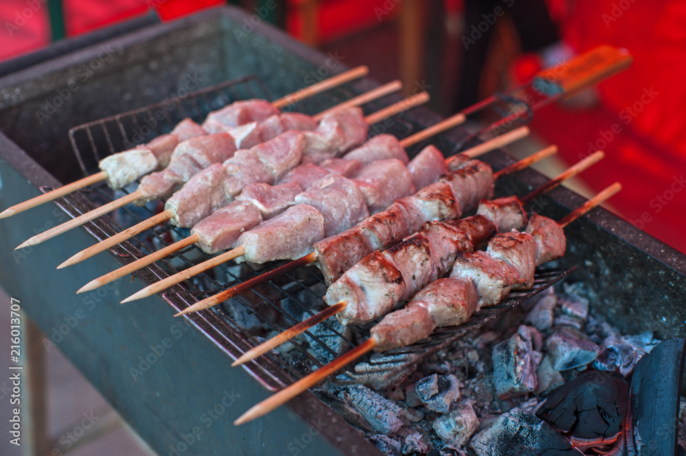 Food and leisure concept - grilling shashlik on a barbecue skewer