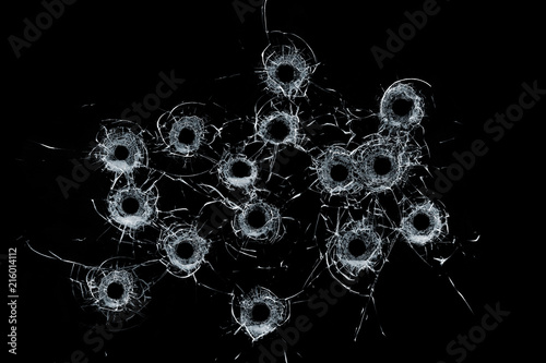 Broken glass multiple bullet holes in glass isolated on black