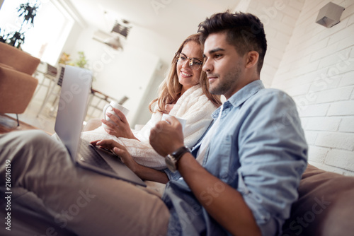 Couple watching a movie on laptop in their living room