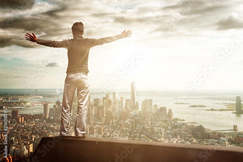 Joyful man with outstretched arms standing on beam