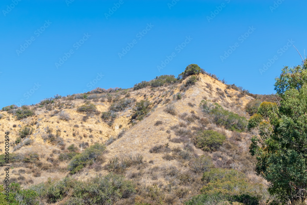 Dry hillsides in the mountains of Southern California on hot summer day with room for text in the sky