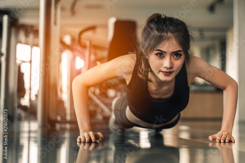 young woman doing push-ups at the gym.