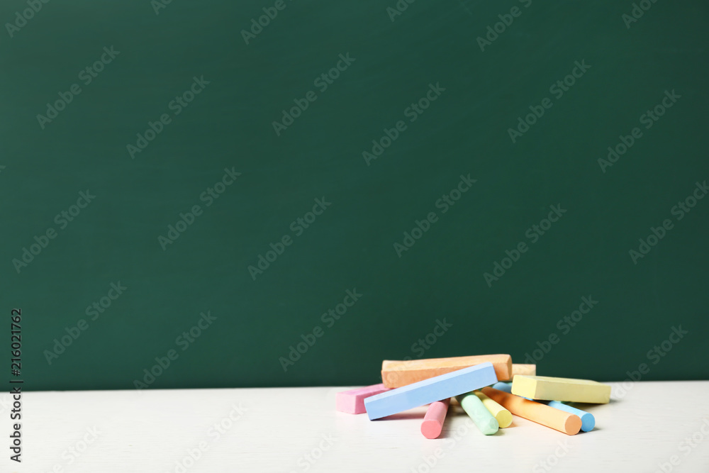 Pieces of chalk on table near board