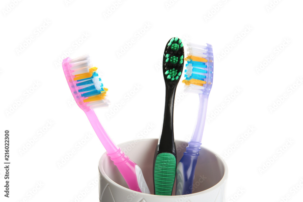 Cup with different toothbrushes on white background. Dental care Cup with different toothbrushes on white background. Dental care
