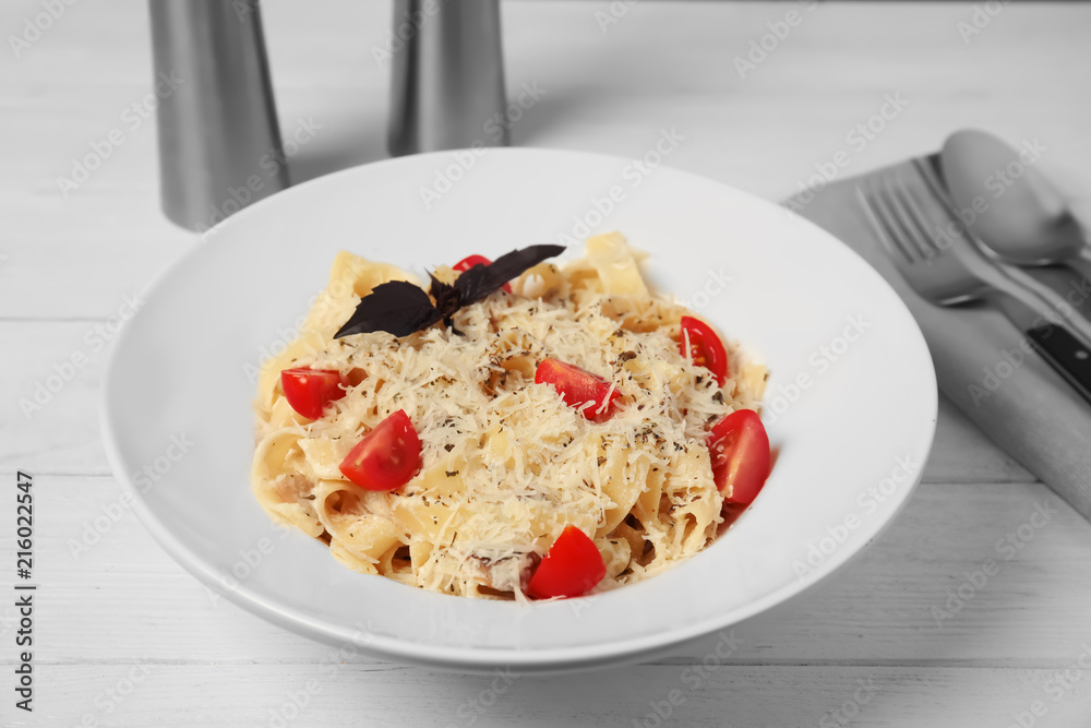 Delicious pasta with tomatoes and cheese on wooden table Delicious pasta with tomatoes and cheese on wooden table
