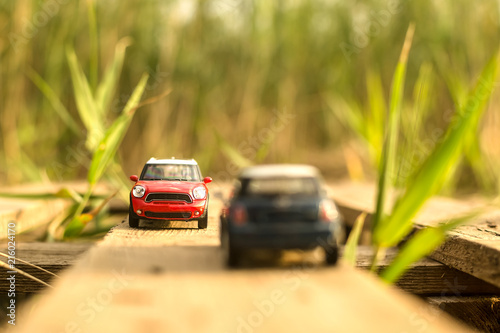red and blue car in miniature oncoming traffic