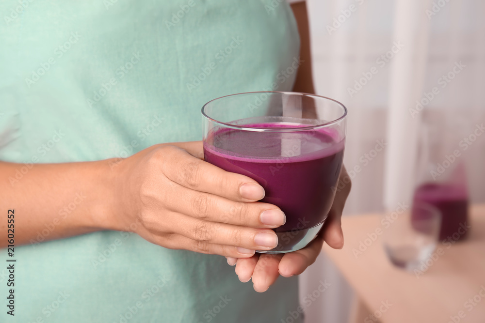 Woman holding glass of delicious acai juice, closeup