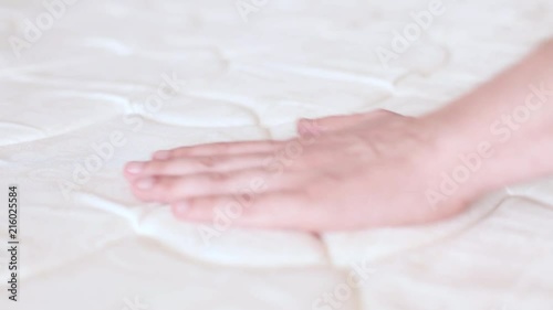 man touch the mattress on the bed