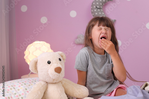 Little girl yawning on bed at home. Time to sleep