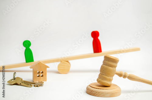 clarification of ownership of the house. wooden figures of people. rivals in business stand on the scales. competition, trial, conflict. victory and defeat. concept of success and power