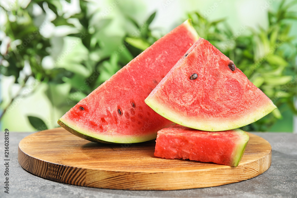 Wooden board with juicy watermelon slices on table Wooden board with juicy watermelon slices on table