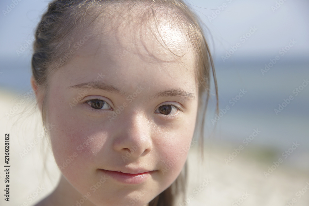 Portrait of down syndrome girl smiling on background of the sea Portrait of down syndrome girl smiling on background of the sea
