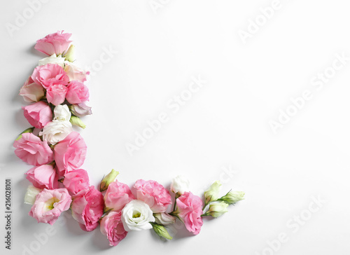 Flat lay composition with beautiful Eustoma flowers on light background